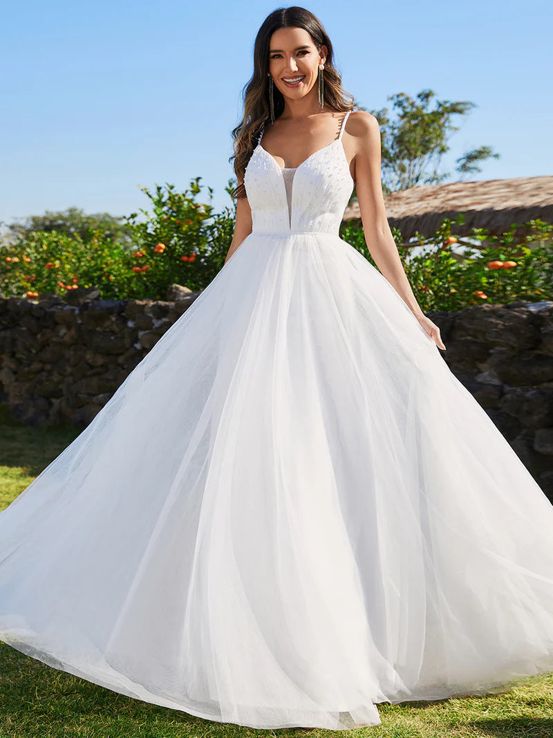 White wedding dress with spaghetti straps and pearl beadings.